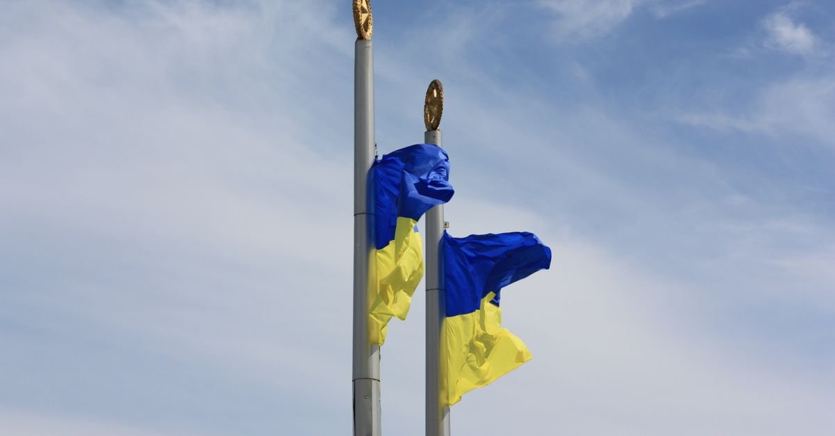 Bandeiras da Ucrânia tremulam em mastros contra o céu azul
